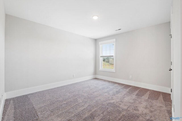 unfurnished room with baseboards, visible vents, and carpet flooring