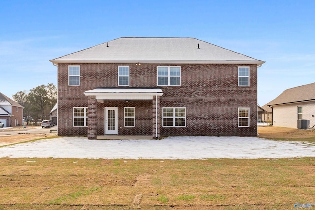 rear view of property with a patio area, a lawn, central AC, and brick siding