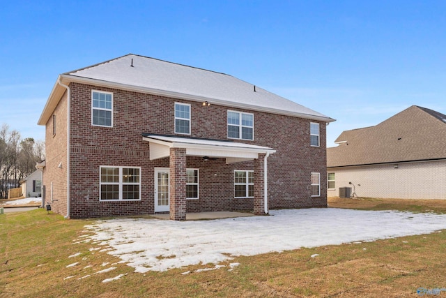 rear view of property with a yard, a patio area, brick siding, and central AC unit