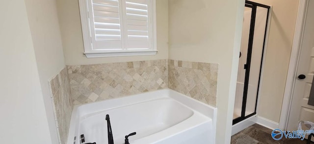 bathroom featuring shower with separate bathtub