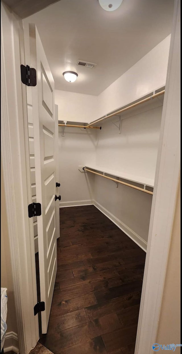 spacious closet with dark hardwood / wood-style flooring