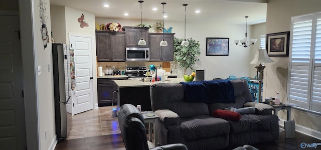 living room with an inviting chandelier and dark wood-type flooring