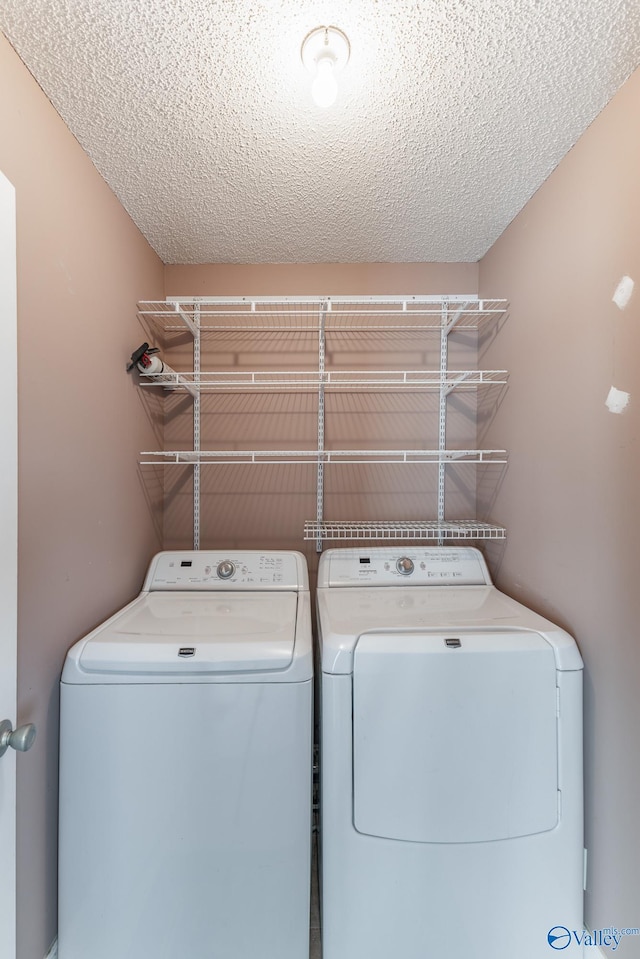 laundry room with separate washer and dryer and a textured ceiling