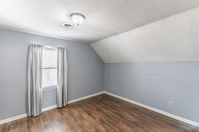 bonus room featuring dark hardwood / wood-style flooring, lofted ceiling, and a textured ceiling