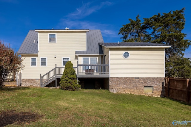 rear view of house with a lawn and a wooden deck