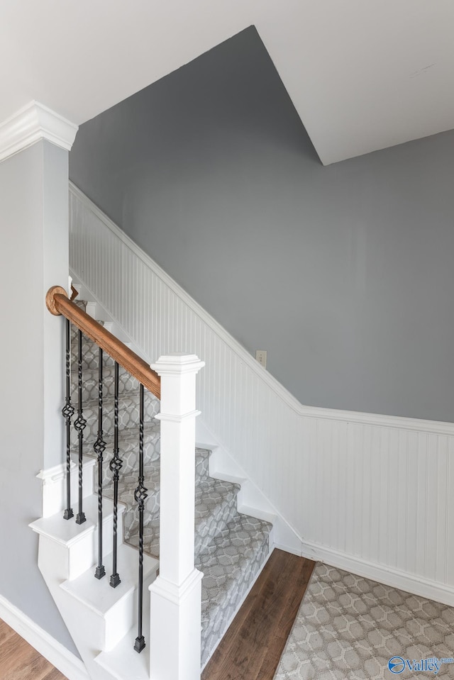 stairway with hardwood / wood-style flooring and crown molding