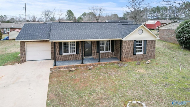 ranch-style house featuring covered porch, a garage, and a front yard