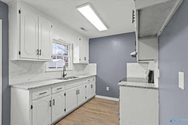 kitchen featuring white cabinets, range, and sink