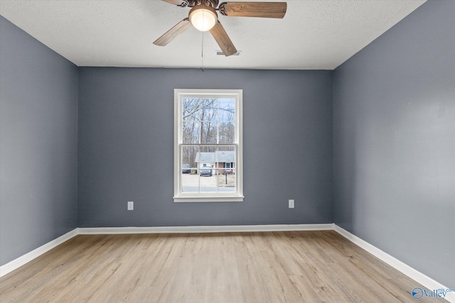 spare room with a textured ceiling, light hardwood / wood-style flooring, and ceiling fan