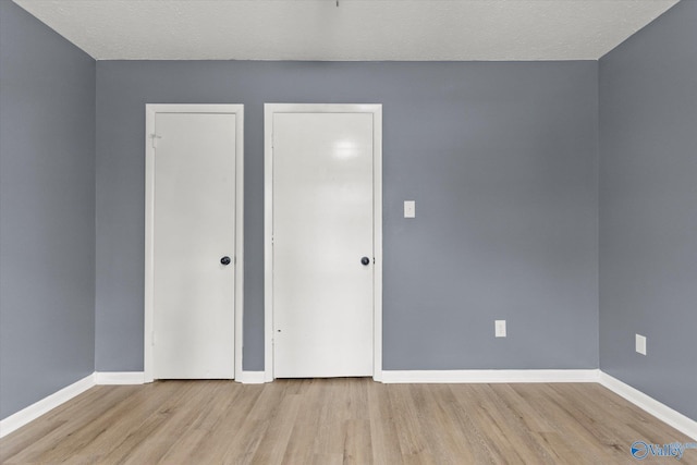 empty room featuring light hardwood / wood-style floors and a textured ceiling