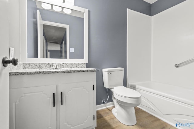 full bathroom featuring vanity, hardwood / wood-style flooring, toilet, and  shower combination