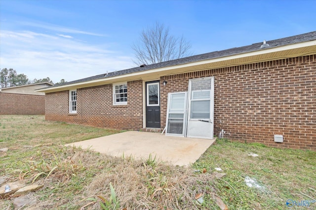 back of property with a yard and a patio