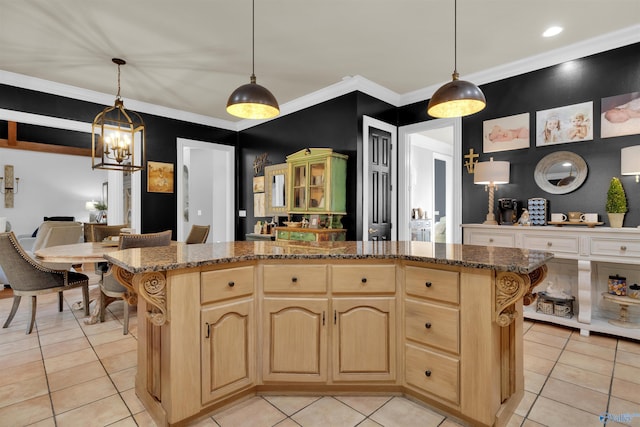 kitchen featuring crown molding, hanging light fixtures, a kitchen island, and light brown cabinets