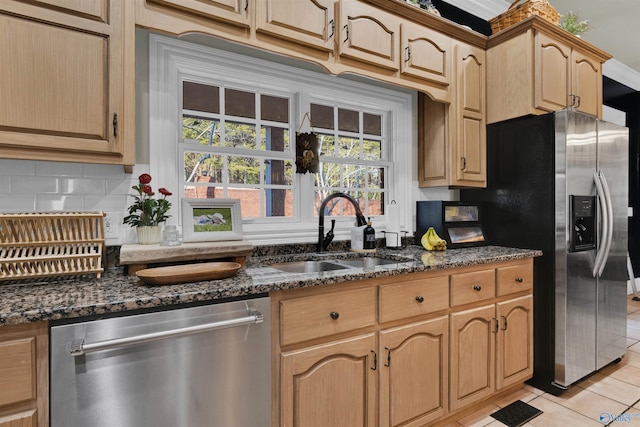 kitchen featuring light tile patterned flooring, stainless steel appliances, sink, and dark stone countertops