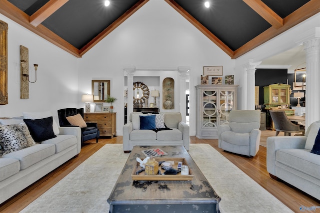 living room featuring hardwood / wood-style flooring, beam ceiling, high vaulted ceiling, and ornate columns