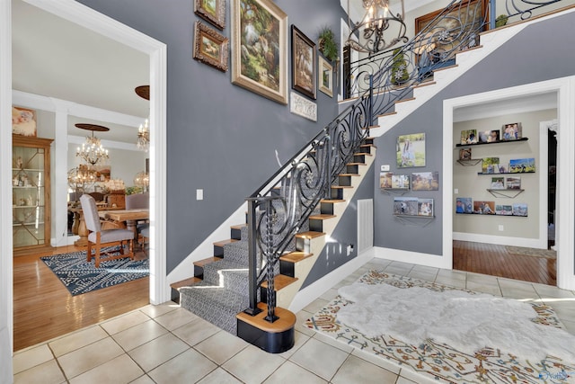 stairway featuring tile patterned floors and a notable chandelier