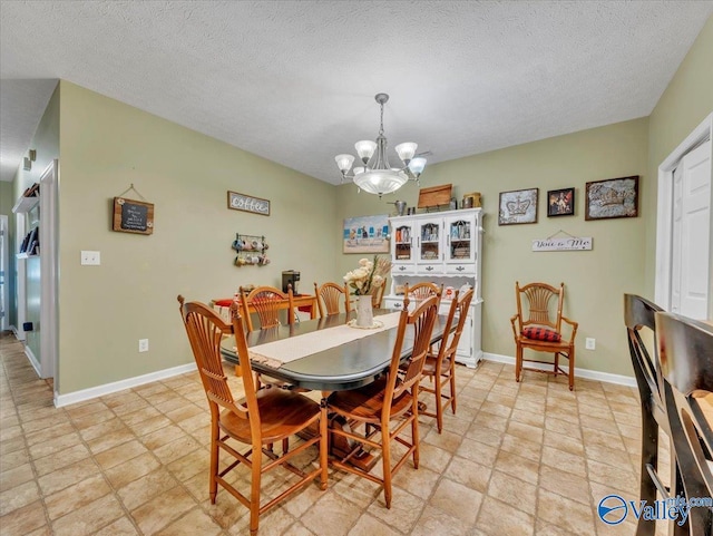 304 Santana Dr, Athens, AL 35611 - dining space with a chandelier, light stone finish flooring, a textured ceiling, and baseboards