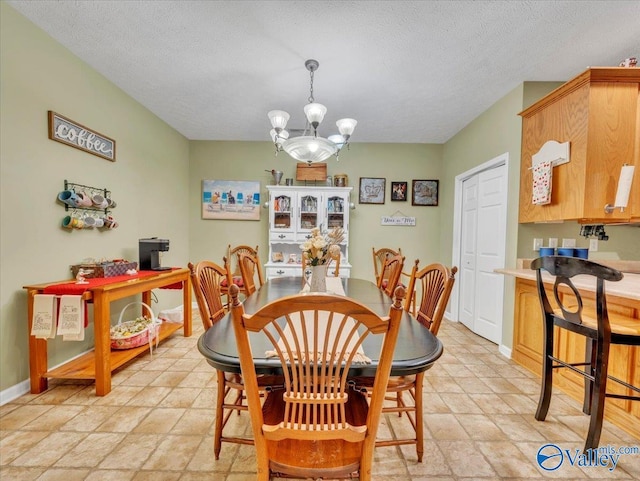 304 Santana Dr, Athens, AL 35611 - dining space with a chandelier, baseboards, a textured ceiling, and light stone finish flooring
