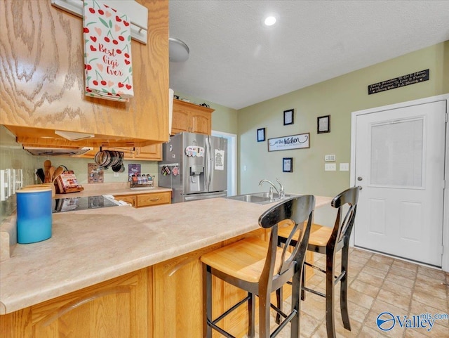 304 Santana Dr, Athens, AL 35611 - kitchen featuring stainless steel fridge with ice dispenser, a peninsula, light countertops, a breakfast bar, and a sink