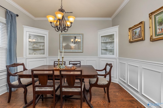 dining area with a chandelier, ornamental molding, a decorative wall, dark wood-style floors, and a wainscoted wall