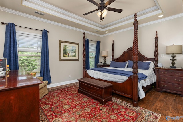 bedroom featuring a raised ceiling, multiple windows, dark wood-style flooring, crown molding, and baseboards