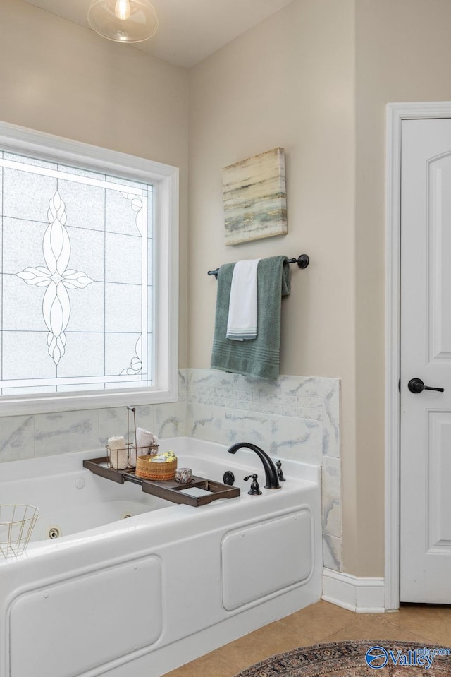 bathroom with a tub with jets and tile patterned floors
