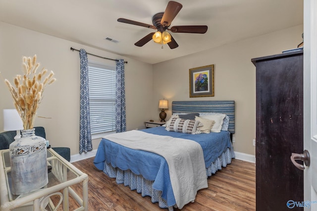bedroom with wood finished floors, baseboards, and a ceiling fan