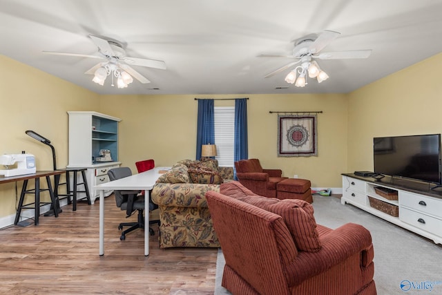 living room featuring ceiling fan, baseboards, and wood finished floors