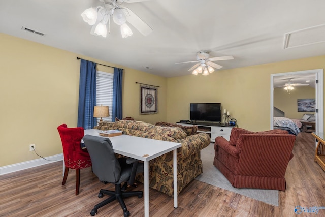 living room with a ceiling fan, wood finished floors, and baseboards