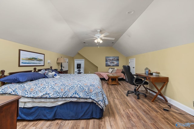 bedroom with vaulted ceiling, wood finished floors, baseboards, and ceiling fan