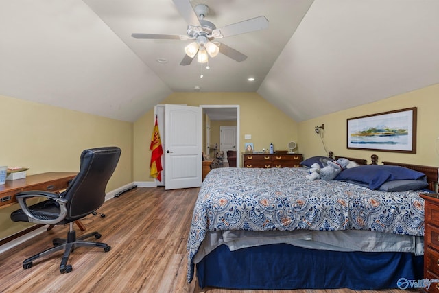 bedroom with wood finished floors, lofted ceiling, a ceiling fan, baseboards, and an office area