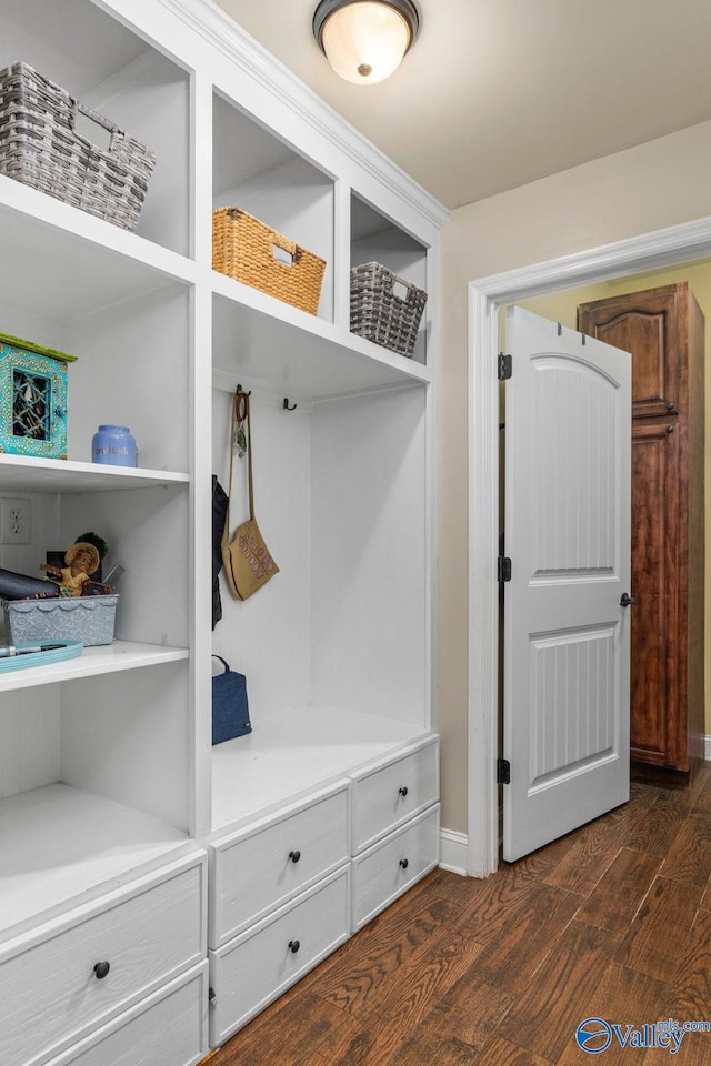mudroom featuring dark wood-type flooring and baseboards