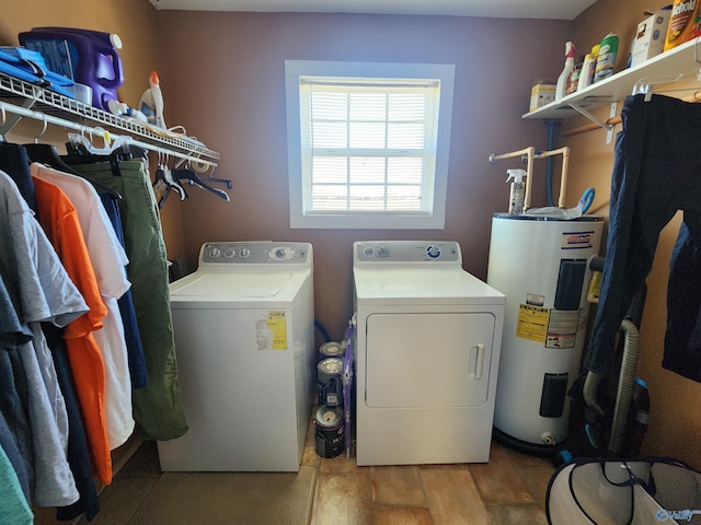clothes washing area with washer and dryer, wood-type flooring, and water heater
