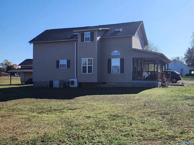 rear view of property with a lawn, ac unit, and central AC