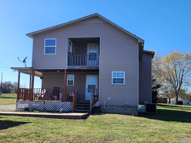 rear view of house with a lawn, a balcony, and a porch