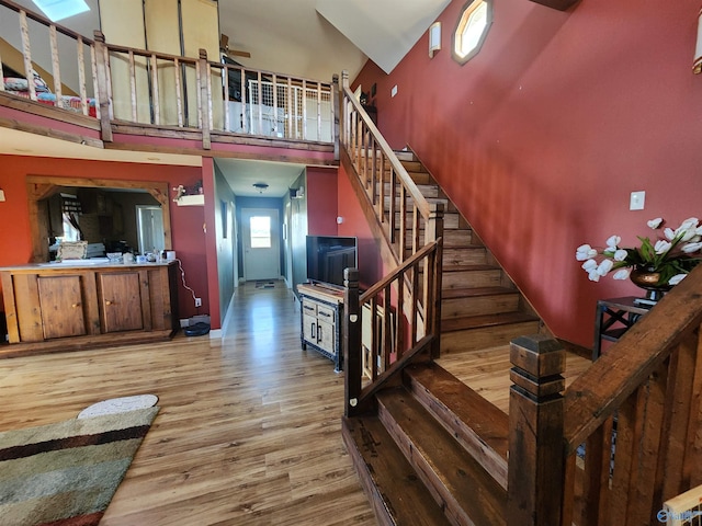 stairway featuring ceiling fan, hardwood / wood-style floors, and a high ceiling