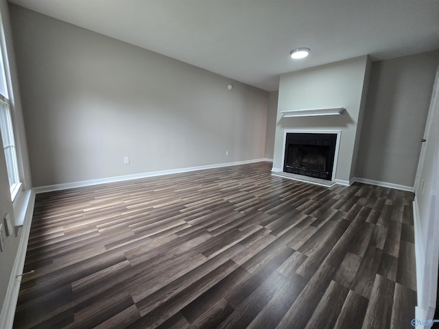 2005 Reaches Pl Unit B, Huntsville, AL 35802 - unfurnished living room with dark wood-style floors, a fireplace with raised hearth, and baseboards
