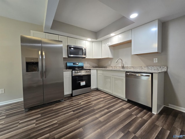 2005 Reaches Pl Unit B, Huntsville, AL 35802 - kitchen featuring appliances with stainless steel finishes, dark wood-style floors, a sink, white cabinets, and baseboards