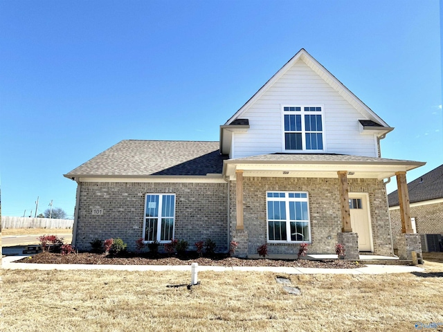 view of front facade with a shingled roof and brick siding