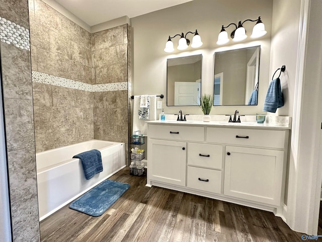 full bath featuring a sink, double vanity, and wood finished floors