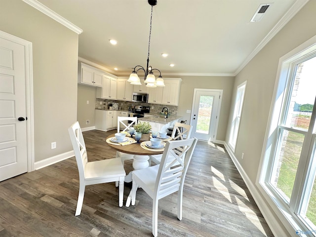 dining space with visible vents, crown molding, baseboards, and wood finished floors