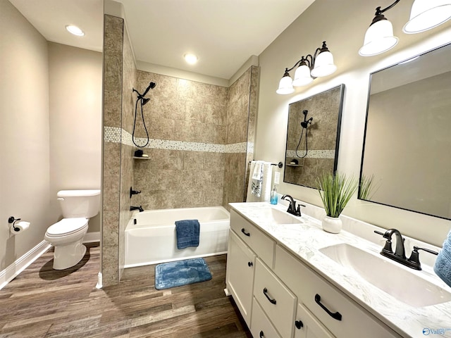 bathroom featuring toilet, shower / bath combination, a sink, and wood finished floors