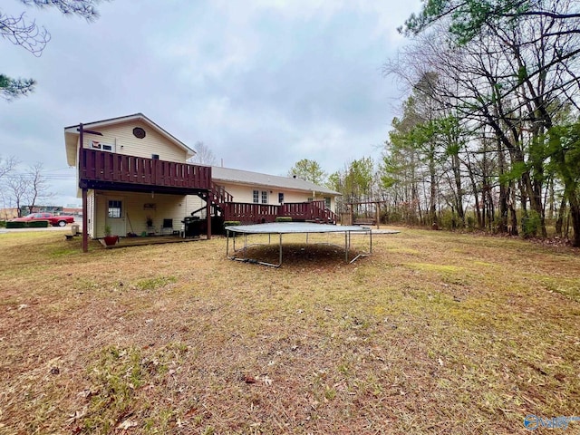 view of yard featuring a deck and a trampoline