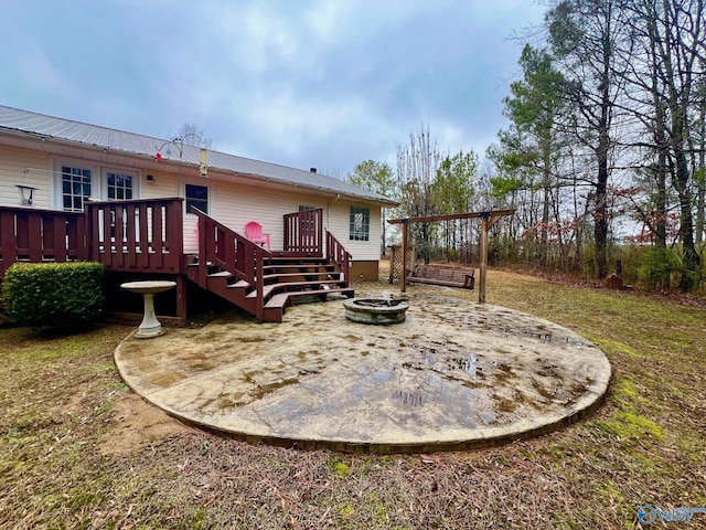 back of property with a fire pit and a deck