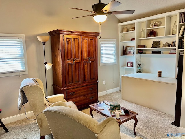 living area featuring vaulted ceiling, light colored carpet, and ceiling fan