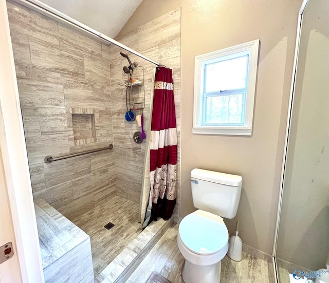 bathroom with curtained shower, vaulted ceiling, and toilet