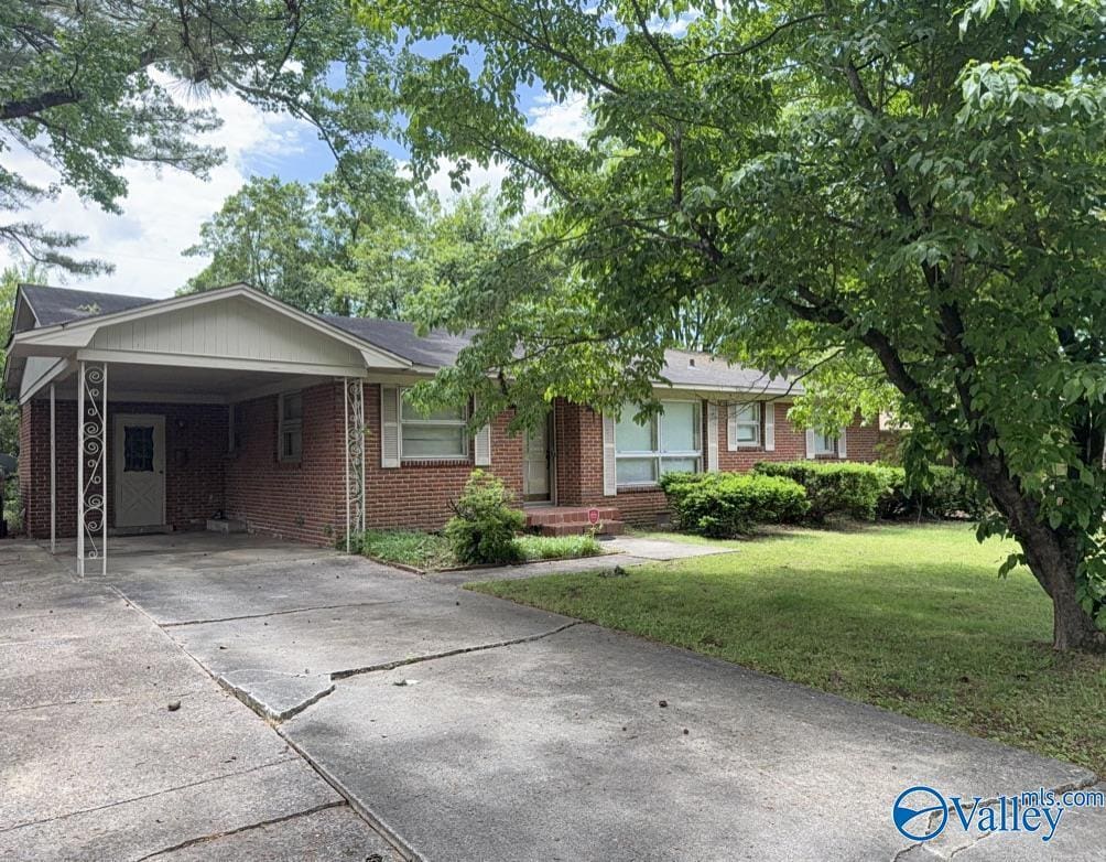 215 Wingate Ave, Huntsville, AL 35802 - ranch-style house featuring concrete driveway, brick siding, a front yard, and an attached carport