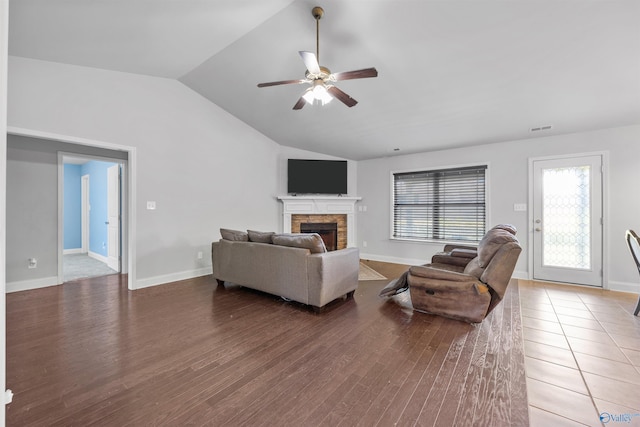 living room with vaulted ceiling, wood-type flooring, ceiling fan, and a fireplace