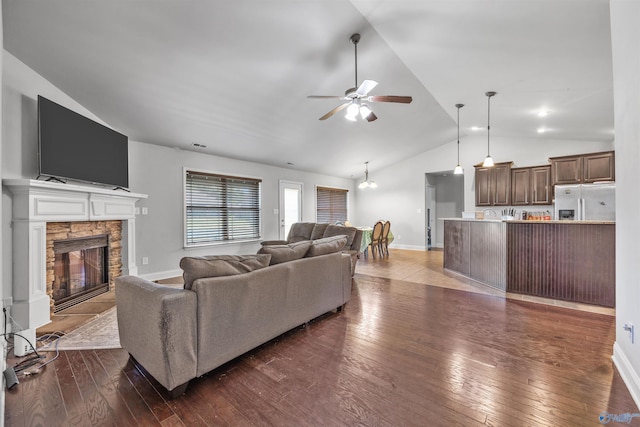 living room with ceiling fan, high vaulted ceiling, a fireplace, and dark hardwood / wood-style flooring