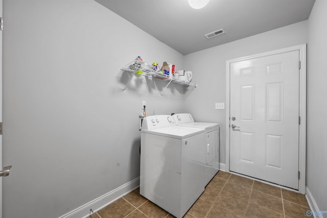 laundry room featuring dark tile patterned floors and washer and clothes dryer